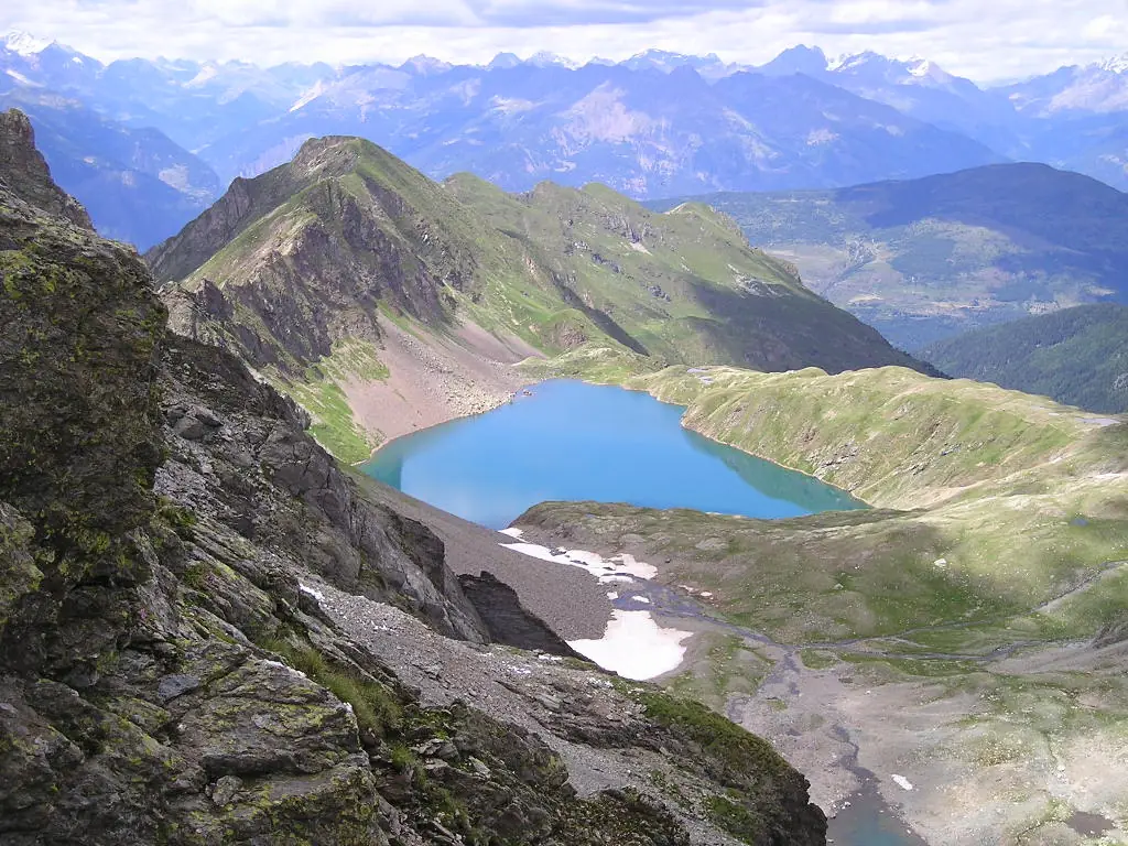 Lago alpino dell'Adamello visto dall'alto, con nevai residui